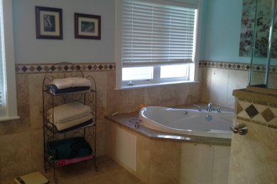 Ejemplo de cuarto de baño principal tradicional de tamaño medio con bañera encastrada, ducha esquinera, sanitario de dos piezas, paredes azules y suelo de baldosas de cerámica