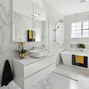 Inspiration for a large contemporary master wet room bathroom in Sydney with white cabinets, a freestanding tub, ceramic tile, white walls, ceramic floors, a vessel sink, marble benchtops, white floor, an open shower, white benchtops, flat-panel cabinets, gray tile and white tile.