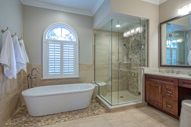 Large modern ensuite bathroom in Atlanta with shaker cabinets, dark wood cabinets, a freestanding bath, a walk-in shower, a two-piece toilet, brown tiles, stone tiles, grey walls, mosaic tile flooring, a submerged sink, quartz worktops, brown floors and grey worktops.