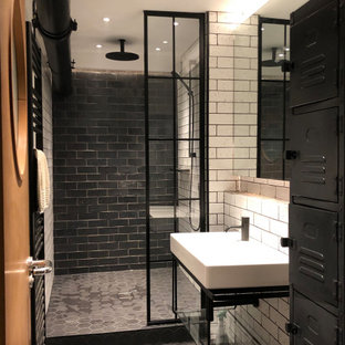 Mittelgroßes Industrial Duschbad mit Duschnische, Metrofliesen, schwarzem Boden, offenen Schränken, schwarzen Schränken, schwarz-weißen Fliesen, Wandwaschbecken, offener Dusche und Zementfliesen in London