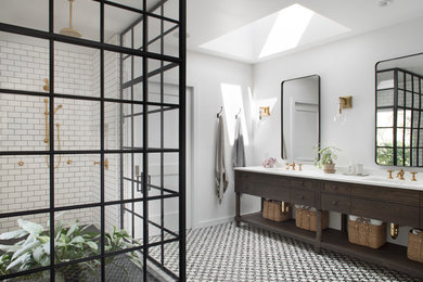 Example of a country white tile and subway tile corner shower design in San Francisco with dark wood cabinets, white walls, an undermount sink, a hinged shower door and flat-panel cabinets