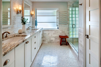 Diseño de cuarto de baño costero con lavabo bajoencimera, armarios estilo shaker, puertas de armario blancas, ducha empotrada, baldosas y/o azulejos beige, paredes beige y suelo con mosaicos de baldosas