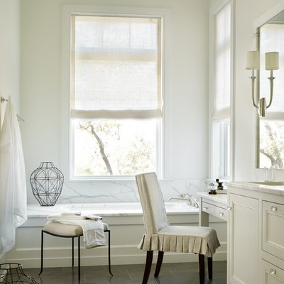 Example of a beach style white tile and stone tile drop-in bathtub design in Atlanta with shaker cabinets, white cabinets and white walls