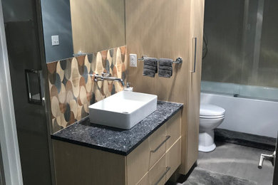 Mid-sized minimalist kids' beige tile and porcelain tile porcelain tile and gray floor bathroom photo in Milwaukee with flat-panel cabinets, light wood cabinets, a one-piece toilet, blue walls, a vessel sink, quartzite countertops, a hinged shower door and blue countertops