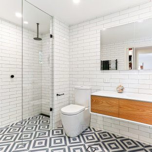 Design ideas for a contemporary 3/4 bathroom in Central Coast with flat-panel cabinets, medium wood cabinets, a curbless shower, a two-piece toilet, white tile, subway tile, an integrated sink, multi-coloured floor, an open shower and white benchtops.