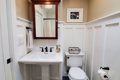 ニューヨークにあるトラディショナルスタイルのおしゃれな浴室 (アルコーブ型浴槽、分離型トイレ、白いタイル、セラミックタイル、磁器タイルの床、ペデスタルシンク、グレーの床、白い洗面カウンター、ニッチ、洗面台1つ、羽目板の壁) の写真
