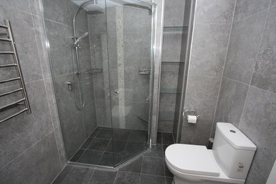 Cette image montre une salle de bain design avec un carrelage gris et des carreaux de porcelaine.