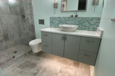 Inspiration pour une salle de bain minimaliste de taille moyenne avec un placard à porte shaker, des portes de placard grises, WC suspendus, un carrelage gris, des carreaux de porcelaine, un mur bleu, un sol en carrelage de porcelaine, un plan de toilette en quartz, un sol gris, un plan de toilette blanc et une vasque.