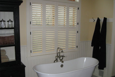 Example of a freestanding bathtub design in Sacramento with yellow walls