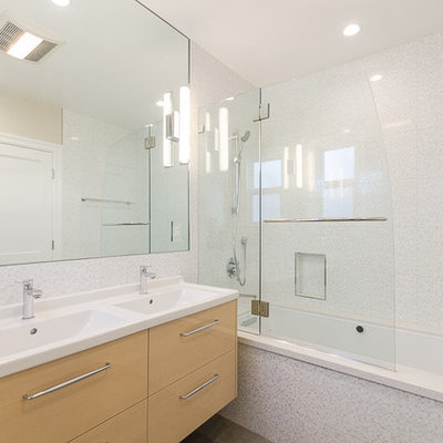 Inspiration for a mid-sized modern white tile, gray tile and mosaic tile tub/shower combo remodel in San Francisco with an integrated sink, flat-panel cabinets, solid surface countertops, an undermount tub, white walls, light wood cabinets and a hinged shower door