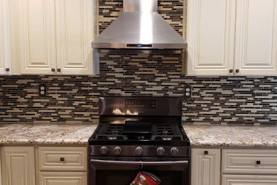 Example of a large minimalist l-shaped vinyl floor and brown floor kitchen pantry design in Sacramento with a single-bowl sink, shaker cabinets, white cabinets, solid surface countertops, multicolored backsplash, matchstick tile backsplash, stainless steel appliances, no island and white countertops