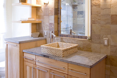 Mid-sized elegant 3/4 beige tile and stone tile slate floor corner bathtub photo in Burlington with a vessel sink, recessed-panel cabinets, light wood cabinets, soapstone countertops, a one-piece toilet and beige walls