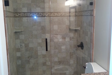 Foto på ett mellanstort funkis badrum med dusch, med luckor med upphöjd panel, skåp i mellenmörkt trä, en dusch i en alkov, brun kakel, grå väggar, klinkergolv i keramik, ett undermonterad handfat, granitbänkskiva, brunt golv och dusch med gångjärnsdörr