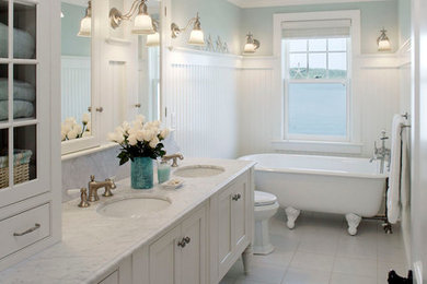 ボストンにある高級な中くらいなトランジショナルスタイルのおしゃれなバスルーム (浴槽なし) (白いキャビネット、分離型トイレ、白いタイル、大理石の洗面台、シェーカースタイル扉のキャビネット、猫足バスタブ、石スラブタイル、青い壁、セラミックタイルの床、アンダーカウンター洗面器、白い床) の写真