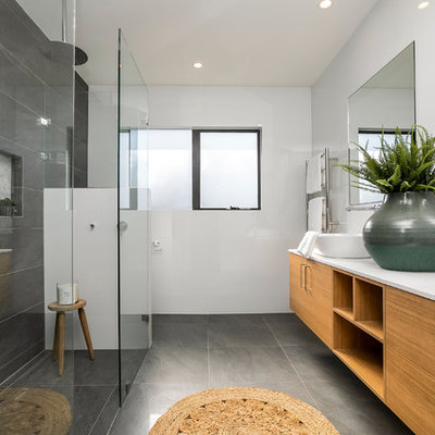 Trendy master gray tile gray floor bathroom photo in Sydney with flat-panel cabinets, brown cabinets, white walls, a vessel sink and white countertops