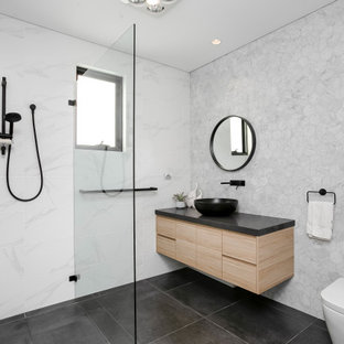 Photo of a mid-sized contemporary bathroom in Sydney with light wood cabinets, a two-piece toilet, black and white tile, marble, ceramic floors, a pedestal sink, engineered quartz benchtops, black floor, black benchtops, an open shower and an open shower.
