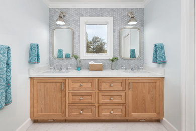 Inspiration for a large transitional 3/4 gray tile and marble tile porcelain tile and gray floor alcove shower remodel in San Francisco with beaded inset cabinets, light wood cabinets, a one-piece toilet, blue walls, an undermount sink, quartz countertops, a hinged shower door and white countertops