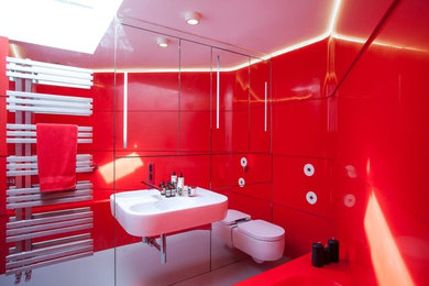 バッキンガムシャーにあるコンテンポラリースタイルのおしゃれな浴室 (人工大理石カウンター、赤いタイル、ドロップイン型浴槽、バリアフリー、赤い壁) の写真