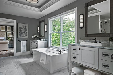 Transitional gray floor freestanding bathtub photo in Other with recessed-panel cabinets, white cabinets, gray walls and a drop-in sink