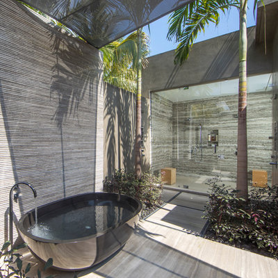 Example of a huge island style master gray tile beige floor bathroom design in Mexico City with gray walls and a hinged shower door