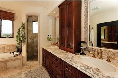 Bathroom - mid-sized traditional master beige tile and mosaic tile travertine floor bathroom idea in San Diego with an undermount sink, raised-panel cabinets, dark wood cabinets, granite countertops and beige walls