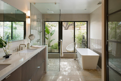 Mid-sized trendy master gray tile beige floor and pebble tile floor bathroom photo in San Diego with flat-panel cabinets, dark wood cabinets, an undermount sink, beige walls, a hinged shower door and white countertops