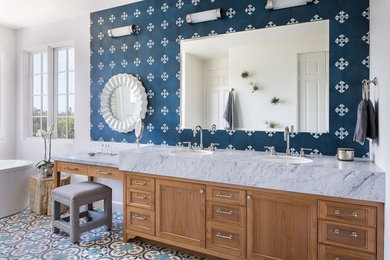 This is an example of a beach style bathroom in Santa Barbara with a freestanding bath, blue tiles, cement tiles, a submerged sink, marble worktops, blue floors, grey worktops, recessed-panel cabinets, medium wood cabinets and white walls.