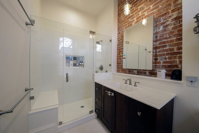 Inspiration for a mid-sized eclectic 3/4 white tile alcove shower remodel in St Louis with beaded inset cabinets, brown cabinets, white walls, an integrated sink and wood countertops