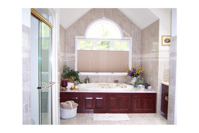 Foto på ett mellanstort vintage en-suite badrum, med luckor med upphöjd panel, skåp i mörkt trä, ett badkar i en alkov, en dusch i en alkov, beige kakel, stenkakel, beige väggar, klinkergolv i keramik och bänkskiva i kalksten