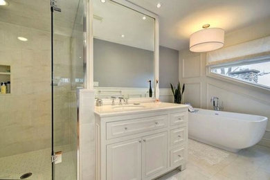 Immagine di una stanza da bagno classica con lavabo sottopiano, vasca freestanding, WC a due pezzi, ante in stile shaker, ante bianche, top in quarzo composito e piastrelle bianche