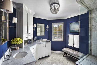 シカゴにある広いコンテンポラリースタイルのおしゃれなマスターバスルーム (アンダーカウンター洗面器、インセット扉のキャビネット、白いキャビネット、大理石の洗面台、コーナー設置型シャワー、白いタイル、青い壁) の写真