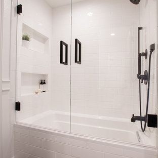Design ideas for a small transitional 3/4 bathroom in Dallas with white cabinets, a drop-in tub, a shower/bathtub combo, a two-piece toilet, white tile, porcelain tile, white walls, limestone floors, an undermount sink, engineered quartz benchtops, black floor, a hinged shower door and white benchtops.
