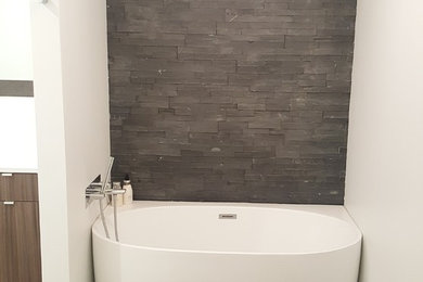 Example of a trendy master gray tile and slate tile porcelain tile and beige floor freestanding bathtub design in Chicago