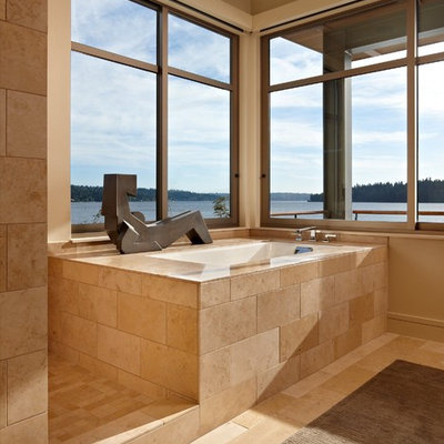 Example of a minimalist limestone tile bathroom design in Seattle with an undermount tub