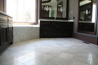 This is an example of a large contemporary ensuite bathroom in Atlanta with recessed-panel cabinets, dark wood cabinets, a built-in bath, grey tiles, white tiles, stone tiles, grey walls, marble flooring, a submerged sink and marble worktops.