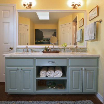 Alcove shower - mid-sized traditional master blue tile concrete floor alcove shower idea in Austin with an undermount sink, raised-panel cabinets, blue cabinets, marble countertops, a two-piece toilet and yellow walls