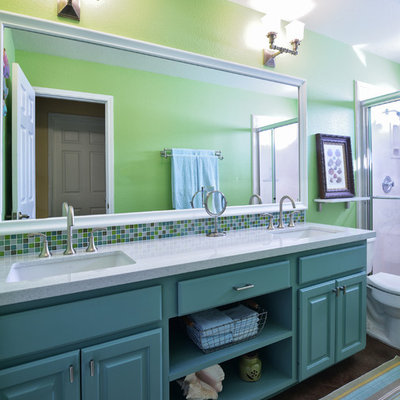 Example of a mid-sized classic 3/4 multicolored tile concrete floor alcove shower design in Austin with an undermount sink, raised-panel cabinets, turquoise cabinets, a two-piece toilet, quartzite countertops and green walls