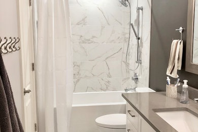 Exempel på ett mellanstort klassiskt grå grått badrum, med skåp i shakerstil, vita skåp, ett badkar i en alkov, en dusch/badkar-kombination, en toalettstol med separat cisternkåpa, flerfärgad kakel, porslinskakel, grå väggar, klinkergolv i keramik, ett undermonterad handfat, bänkskiva i kvarts, flerfärgat golv och dusch med duschdraperi