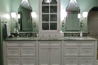 Klassisk inredning av ett stort en-suite badrum, med ett undermonterad handfat, släta luckor, vita skåp, granitbänkskiva, ett platsbyggt badkar, en hörndusch, grön kakel, porslinskakel, gröna väggar och klinkergolv i porslin