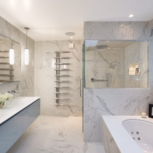 Photo of a contemporary master bathroom in London with a wall-mount sink, flat-panel cabinets, a hot tub and marble.