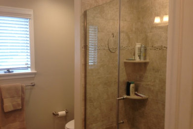 Mid-sized transitional master beige tile and ceramic tile porcelain tile alcove shower photo in Philadelphia with raised-panel cabinets, dark wood cabinets, a two-piece toilet, beige walls, an undermount sink and granite countertops