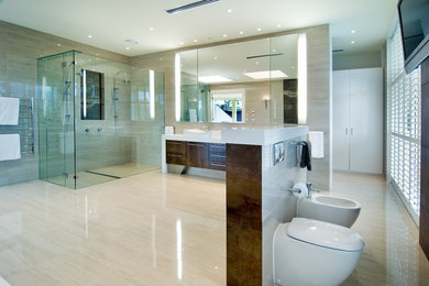 メルボルンにあるラグジュアリーなコンテンポラリースタイルのおしゃれな浴室 (ベッセル式洗面器、フラットパネル扉のキャビネット、濃色木目調キャビネット、アルコーブ型シャワー、ビデ、ベージュのタイル) の写真