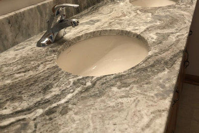 グランドラピッズにある中くらいなおしゃれな浴室 (アンダーカウンター洗面器、御影石の洗面台) の写真