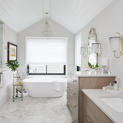 Example of a transitional white floor freestanding bathtub design in Grand Rapids with flat-panel cabinets, dark wood cabinets, gray walls, an undermount sink and gray countertops