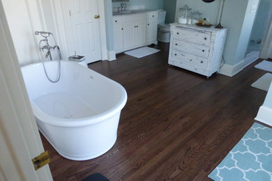 Inspiration for a mid-sized transitional master medium tone wood floor and brown floor bathroom remodel in Kansas City with raised-panel cabinets, white cabinets, a two-piece toilet, blue walls, an undermount sink and marble countertops