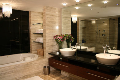 Bathroom - large contemporary beige tile and stone tile limestone floor and beige floor bathroom idea in Miami with flat-panel cabinets, brown cabinets, a one-piece toilet, beige walls, a vessel sink, granite countertops and a hinged shower door