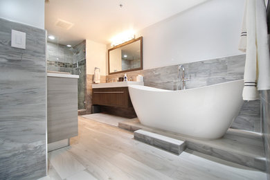 Bathroom - large transitional master white tile and porcelain tile porcelain tile and gray floor bathroom idea in Miami with flat-panel cabinets, brown cabinets, a one-piece toilet, white walls, an undermount sink, quartz countertops and a hinged shower door