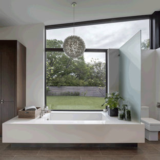 Doorless shower - huge modern master ceramic tile and brown floor doorless shower idea in Dallas with flat-panel cabinets, medium tone wood cabinets, an undermount tub, a one-piece toilet, white walls, quartz countertops, a hinged shower door and white countertops