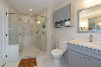 Large traditional bathroom in Seattle with recessed-panel cabinets, grey cabinets, an alcove shower, a two-piece toilet, grey tiles, porcelain tiles, grey walls, porcelain flooring, a submerged sink and engineered stone worktops.