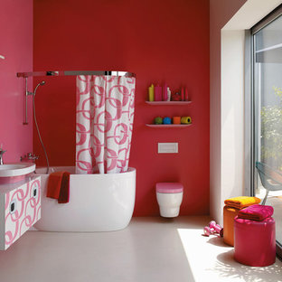 Idéer för mellanstora funkis en-suite badrum, med släta luckor, vita skåp, ett platsbyggt badkar, en dusch/badkar-kombination, en vägghängd toalettstol, rosa väggar, betonggolv, ett fristående handfat och bänkskiva i akrylsten